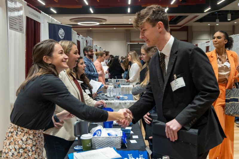 Students shaking hands at a career fair