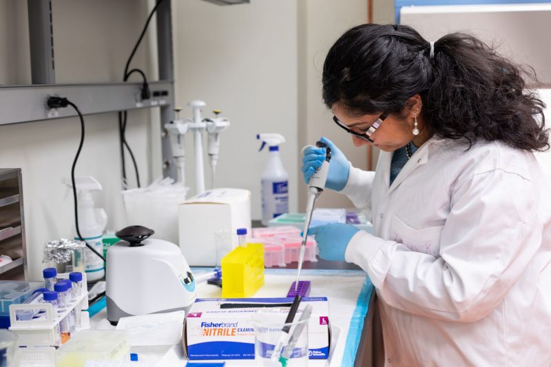 Photo of Zerin working in a lab, pipetting