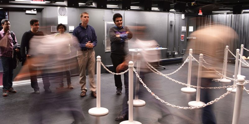 Jonathan Boreyko (left) and graduate student Farzad Ahmadi monitor pedestrian spacing as a line empties at The Cube in Virginia Tech’s Moss Arts Center.