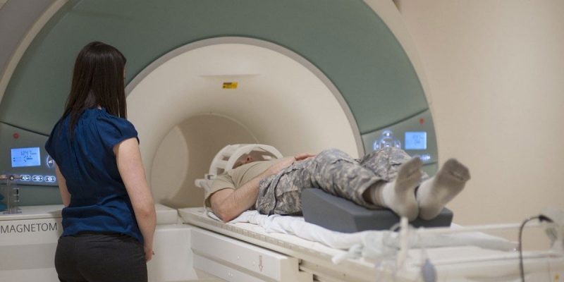 A photo of a man preparing for an MRI