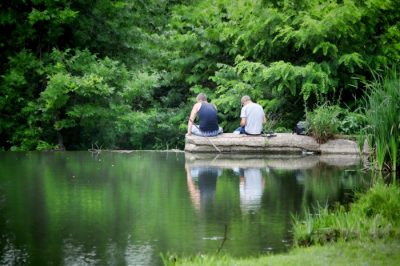 Two people sitting on a rock in the river