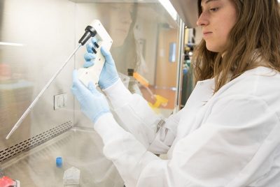 A BEAM graduate student measures precise volumes of liquids in the lab