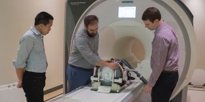 A photo of Stephen LaConte, Douglas Chan, and Nate Kelm with an MRI