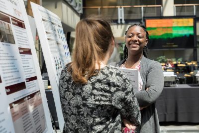 Cherice Hughes-Oliver speaks with another presenter at the 2018 SBES Student Symposium