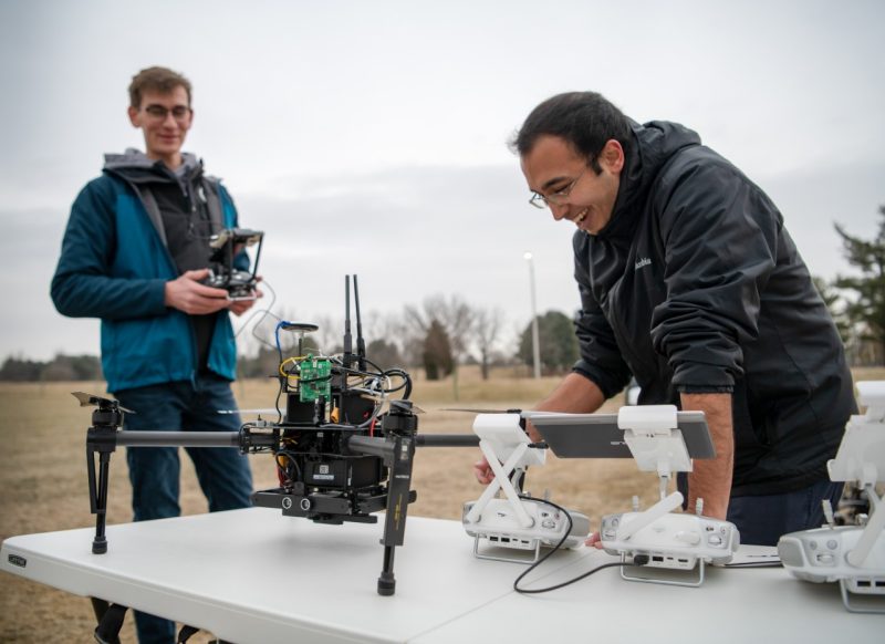 Picture of two electrical and computer engineering graduate students working with drones