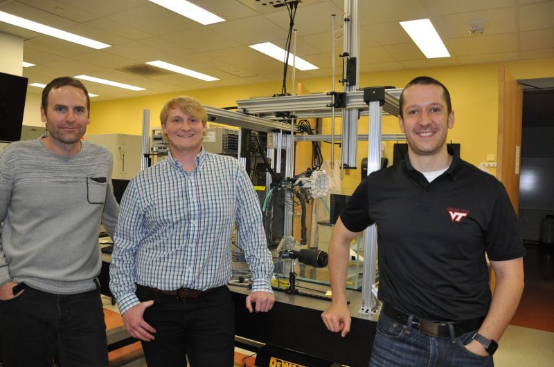 Jason Holliday, Hal Holmes, and Eli Vlaisavljevich (left to right) pictured in front of a customized histotripsy transducer in the Vlaisavljevich Laboratory. 